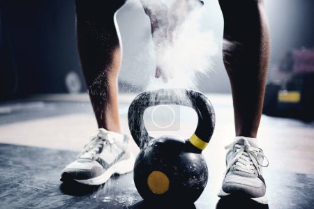 Photo for Person, hand and kettlebell with powder at gym for strength training, grip and fitness challenge on floor. Athlete, bodybuilder and workout equipment for muscle exercise, power and chalk in body care. - Royalty Free Image