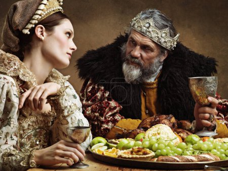 Photo for King, queen and together with feast and wine in banquet hall for fine dinning for tradition or culture in palace. Monarch, sovereign and royalty with buffet for luxury, bored and vintage with goblet - Royalty Free Image