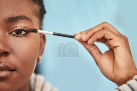 Black woman, portrait and eyeliner product for makeup with cosmetics, skin and face for natural look. Model, studio and brush for beauty regimen, mascara and eyelash on eyelid for fashion show.