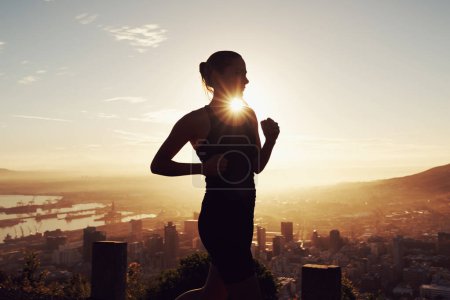 Photo for Fitness, running and woman in silhouette on mountain for health, wellness and strong body development. Workout, exercise and girl runner on sunset path in nature for training, performance and city. - Royalty Free Image
