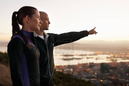 Photo for Exercise, nature and couple with hand pointing to sunset, city view or fitness vision. Health, training and sports people outside planning running route, workout or speed target together at sunrise. - Royalty Free Image