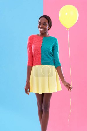 Photo for Black woman, fashion and portrait, balloon and smile or happiness with color block background. Stylish, trendy and vibrant for female model person, fun and unique retro clothing for hipster in studio. - Royalty Free Image