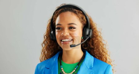 Photo for Happy woman, consultant and talking with headphones for customer service or call center on a gray studio background. Young female person or agent consulting for online advice or help on mockup space. - Royalty Free Image