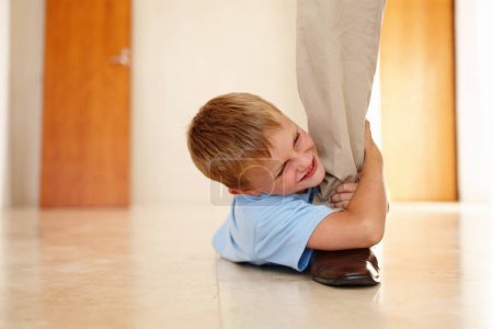 Photo for Child, happy and holding dads leg on floor for playing, bonding or family game at home. Kid, smiling and on ground pulling fathers foot for entertainment, amusement or relationship development. - Royalty Free Image