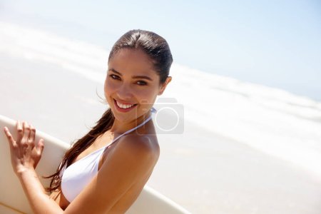 Photo for Woman, beach and surfboard for surfing or portrait with bikini, adventure and fitness with blue sky. Tourist, person and surfer by ocean in morning for holiday, vacation or mockup space in California. - Royalty Free Image