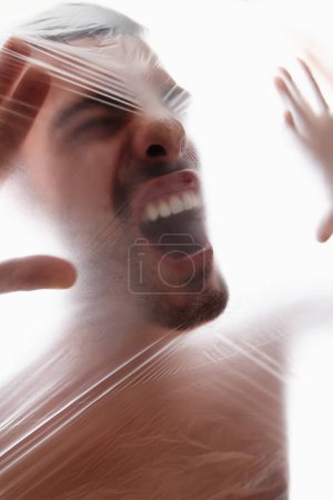 Male person, plastic and bag with choking, gasping and struggle for air in white background. Man, expression and suffocating in crisis for awareness, help and anxiety in mental health or wellness.