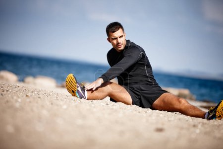 Photo for Man, stretching and blue sky at beach for exercise with fitness motivation, sand and sports. Male person, training and nature by ocean with workout for wellness, strong body and health activity. - Royalty Free Image