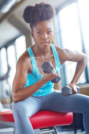 Photo for Gym, portrait and black woman with dumbbell, fitness and training for strong arm challenge. Sports, wellness and athlete with weightlifting exercise, performance and health, cardio or body workout. - Royalty Free Image
