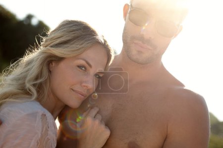 Photo for Couple, portrait and lens flare on vacation with hug for love in relationship in white background. People, embrace and travel on holiday for trip, summer and sun in bali in outdoor with sunshine. - Royalty Free Image