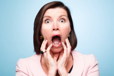 Photo for Portrait, wow and surprise of shocked woman with horror, fear or scared in studio isolated on blue background. Face, omg and wtf announcement of model with secret, news or emoji expression for gossip. - Royalty Free Image