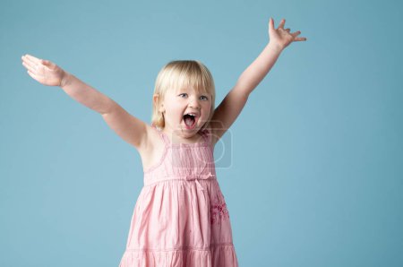 Studio, child or girl excited with scream for surprise, happy or isolated on blue background. Model, backdrop or kid for announcement with motor skills for wow, omg or shocked with mind blown.