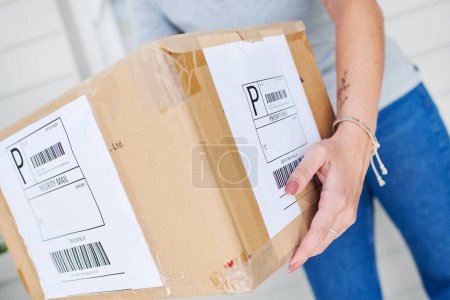 Woman, hands and box for delivery of order, shipping and parcel by home for transport of purchase. Closeup, package and import or online store and postage, employee and supply chain for distribution.