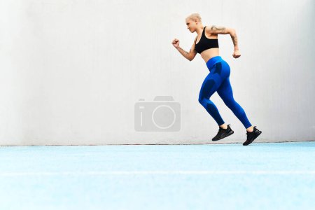 Photo for Woman, running and training in stadium with cardio workout for race competition, fitness and marathon. Female athlete, outdoor exercise and speed at run track for health, strong body and sports event. - Royalty Free Image