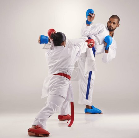 Photo for People, karate and kick to practice in studio on white background with focus to fight or train for competition. Mma, sport and glove for fitness with technique, commitment and confidence as fighter. - Royalty Free Image