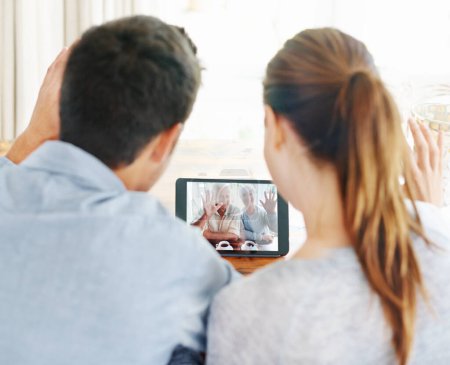 Photo for Couple, tablet and video call with grandparents for greeting or online conversation at home. Rear view of man and woman talking or waving with technology for virtual meeting, talk or communication. - Royalty Free Image