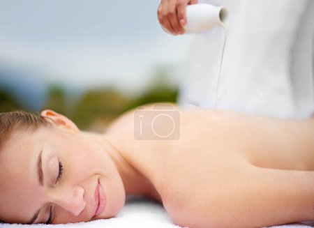 Photo for Woman, oil and massage table in spa, therapy and self care for body wellness and resting for tension. Comfortable and resort with client, stress free and healing, calm session and cosmetology. - Royalty Free Image