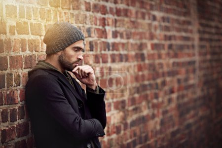 Photo for Fashion, man and thinking in brick wall outdoor with trendy, cool and style for urban with idea. Male person, choice and planning for weekend or holiday with winter outfit and stylish in Germany. - Royalty Free Image