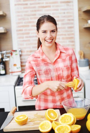 Photo for Woman, kitchen and happy or squeeze orange for juice in bowl for health, nutrition and diet with ingredients. Home, portrait and smile with fruit for sweet flavor or lunch snack and fresh food. - Royalty Free Image