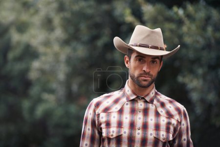 Photo for Man, portrait and outdoor cowboy fashion, western culture and countryside ranch in Texas. Male person, hat and flannel shirt for farmer aesthetic, nature and plaid style by trees or outside bush. - Royalty Free Image