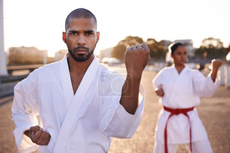 Photo for Serious people, karate and martial arts with personal trainer for self defense, class or teaching in city street. Man and woman fighter or athlete in fitness training, kata or technique in urban town. - Royalty Free Image