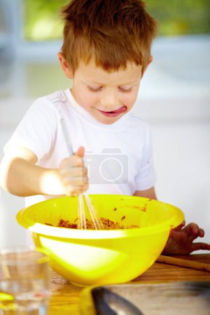 Photo for Boy, bowl or whip in baking, nutrition or playful activity as growth, development or milestone. Male child, naughty or mixing of food, ingredients or meal prep as sweet, dessert or snack in kitchen. - Royalty Free Image