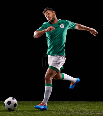 Photo for Man, ball and soccer for sport and fitness for game, active and sportswear on grass or field. Role model, athlete or player and practice for kick, competitive and score in night on dark background. - Royalty Free Image
