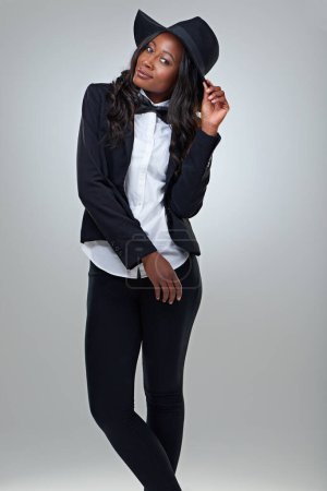 Photo for Fashion, portrait and black woman in a suit in studio for edgy, elegance or chic style on grey background. Hat, clothes and African female model with cool, trendy or stylish, bowtie or outfit choice. - Royalty Free Image