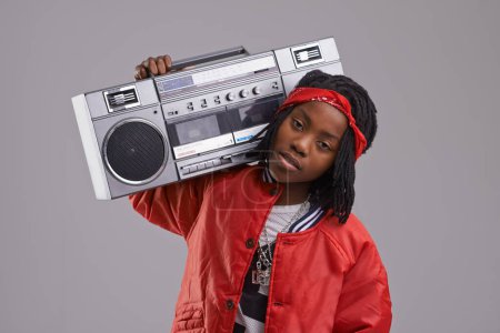 Photo for Child, hip hop and portrait with radio for rap music and dance in a studio with urban clothing. Fashion, African kid and boombox with trendy clothes and youth swag with confidence and grey background. - Royalty Free Image