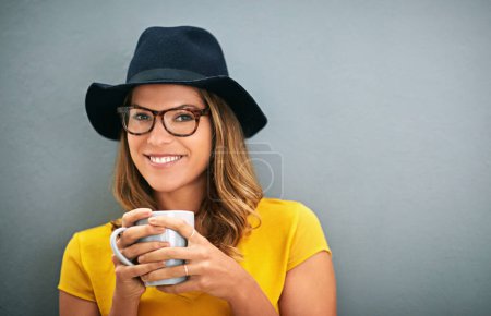 Gesicht, Frau und Kaffee mit Brille für Vision, Koffein und gute Laune im Studio mit Lächeln auf grauem Hintergrund. Attrappe, Brille und warmes Getränk mit Portrait, Relax für Positivität und Drink.