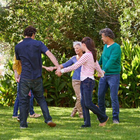 Familia feliz, tomados de la mano y bailar juntos al aire libre o jugar en verano en un círculo con los abuelos. Anillo de un rosado, sonrisa y los niños en el jardín de vacaciones, vacaciones y vinculación con los padres.