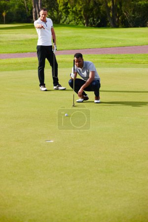 Photo for Athletes, play and aim golf ball at opening for sport, fitness or competition on summer day. Men, watch and concentrate in outdoor tournament on green course for putt, par or birdie on last hole. - Royalty Free Image