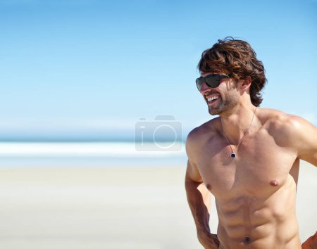 Photo for Man, shirtless and smile on beach for tan, outdoor recreation and vacation for summer trip and travel. Young person or male tourist and happy for bliss or enjoyment in sun for holiday break on mockup. - Royalty Free Image