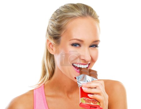 Photo for White background, portrait and bite of chocolate by woman, smile and cheat day on diet for athlete. Adult, female person and girl with happy for dessert to enjoy after exercise or workout in studio. - Royalty Free Image