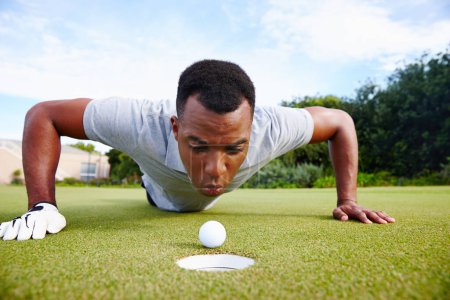 Photo for Desperate golfer and cheating, blow ball in hole for victory on green field at competition. Serious man and closeup for challenge, sports fraud on target outdoors on grass or lawn at country club. - Royalty Free Image