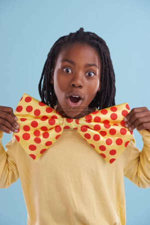 Photo for Child, bowtie and portrait in studio for costume, clothes and fashion for silly, comic and bold with dots. African boy or tween and wow expression for cosplay, crazy and funny for joy and dress up. - Royalty Free Image