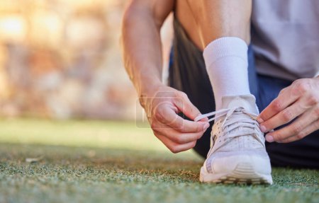 Photo for Running, fitness and person tying shoes for cardio workout, marathon training and exercise. Sports, runner and closeup of man with sneakers for performance, wellness and laces outdoors on grass. - Royalty Free Image