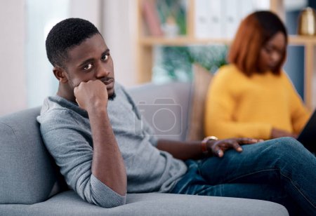 Divorce, fight and angry black couple on sofa with stress, dispute or argument in their home. Marriage, conflict and African man frustrated, overthinking or ignore liar wife in living room with doubt.