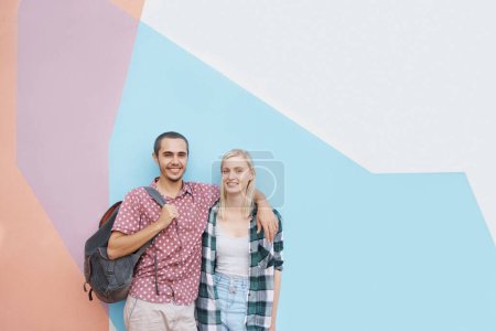 Photo for Couple, students and happy portrait in studio for higher education or knowledge, hug and bonding for love. People or gen z friends, color block and scholarship for university, college and tourism - Royalty Free Image