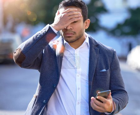 Businessman, stress and walking with phone, message and outdoor or upset with face palm. Hispanic person ,frustrated and bad news for investments, problem and mobile while worried, work and urban.