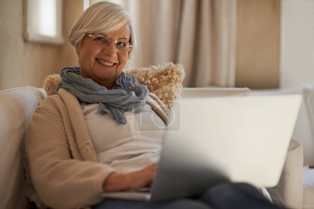 Téléchargez les photos : Canapé, ordinateur portable et portrait de femme âgée avec sourire pour le travail à distance, le commerce électronique et la recherche dans le salon. Personne mûre, visage et ordinateur pour planifier, planifier et dactylographier l'email au client. - en image libre de droit