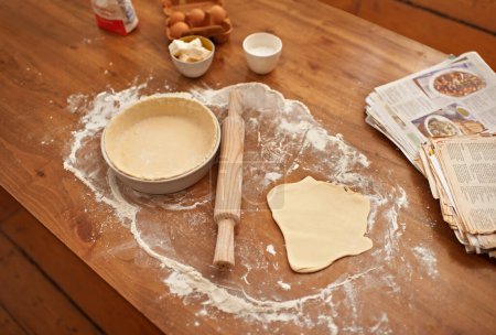 Préparation, comptoir et ingrédients pour pâte ou pâtisserie sans personne, prêt pour le remplissage et la cuisson ou la cuisson pour les vacances de Pâques. Livres, recettes et poêles pour tarte sucrée faite à la main pour dessert ou en-cas.