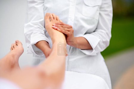 Photo for Woman, relax and foot for massage at spa from therapist for treatment or pedicure with hands for health or skincare. Professional, therapy and zen with body care or healing for wellness at resort. - Royalty Free Image