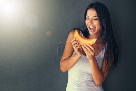 Photo for Slice of melon, happy and woman with nutrition, wellness and lens flare on a grey background. Person, mockup space and model with a fruit and excited with diet plan and healthy living with vegetarian. - Royalty Free Image