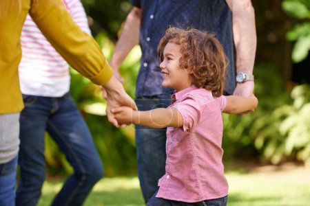 Joyeux famille, tenant la main et les enfants dansent en plein air ou jouent au jeu en été ensemble dans un cercle au parc. Sonnez une rose, sourire et enfant dans le jardin en vacances, vacances et liens avec les parents dans la nature.