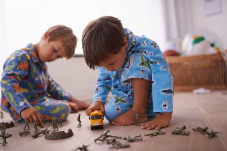 Photo for Boys, playing and children in pajamas with toys for fun with action figures, car or games. Brothers, child development and young kids bonding together in playroom for learning at family home - Royalty Free Image