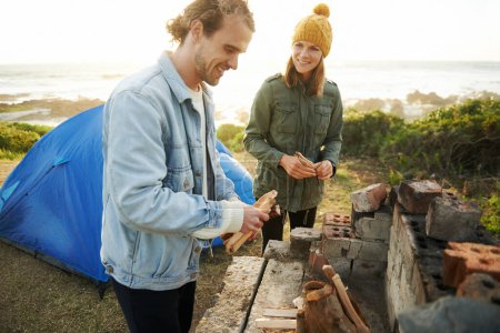 Photo for Nature, happy and couple with fire for camping on romantic vacation, adventure or holiday. Smile, love and young man and woman with flame for warm on outdoor winter weekend trip with tent together - Royalty Free Image