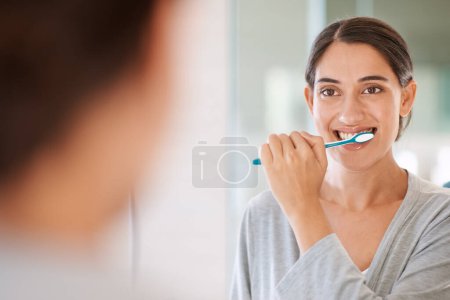 Téléchargez les photos : Femme, brossant les dents et souriant le matin par miroir pour la santé, le bien-être ou l'autosoin pour respirer à la maison. Fille, personne et heureux avec brosse à dents, la bouche et le nettoyage pour l'hygiène à l'appartement au Chili. - en image libre de droit