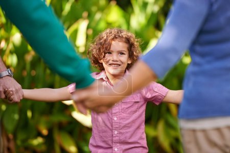 Joyeux famille, tenant la main et l'enfant danser en plein air ou jouer au jeu en été ensemble dans un cercle au parc. Sonnez une rose, sourire et enfant dans le jardin en vacances, vacances et liens avec les parents dans la nature.