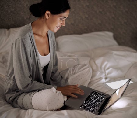 Photo for Night, bedroom and woman with smile for laptop on social media, chatting and texting on site of app. Bed, female person and girl with technology for reading ebook to relax and online with internet. - Royalty Free Image