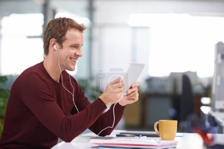 Tablet, smile and businessman with earphones, watching at desk in office workplace. Happy, technology and business videos or social media streaming, elearning or internet research for online project.
